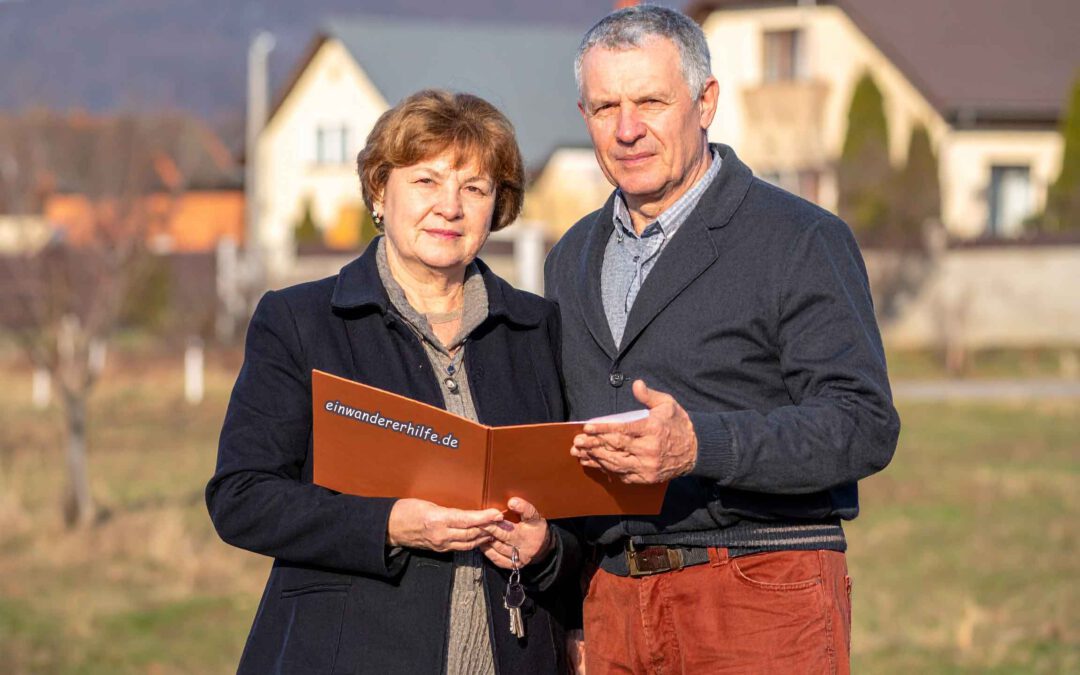 Paar prüft Unterlagen und Checkliste beim Haus kaufen in Ungarn vor einem Wohnhaus als Vorbereitung auf den Immobilienkauf